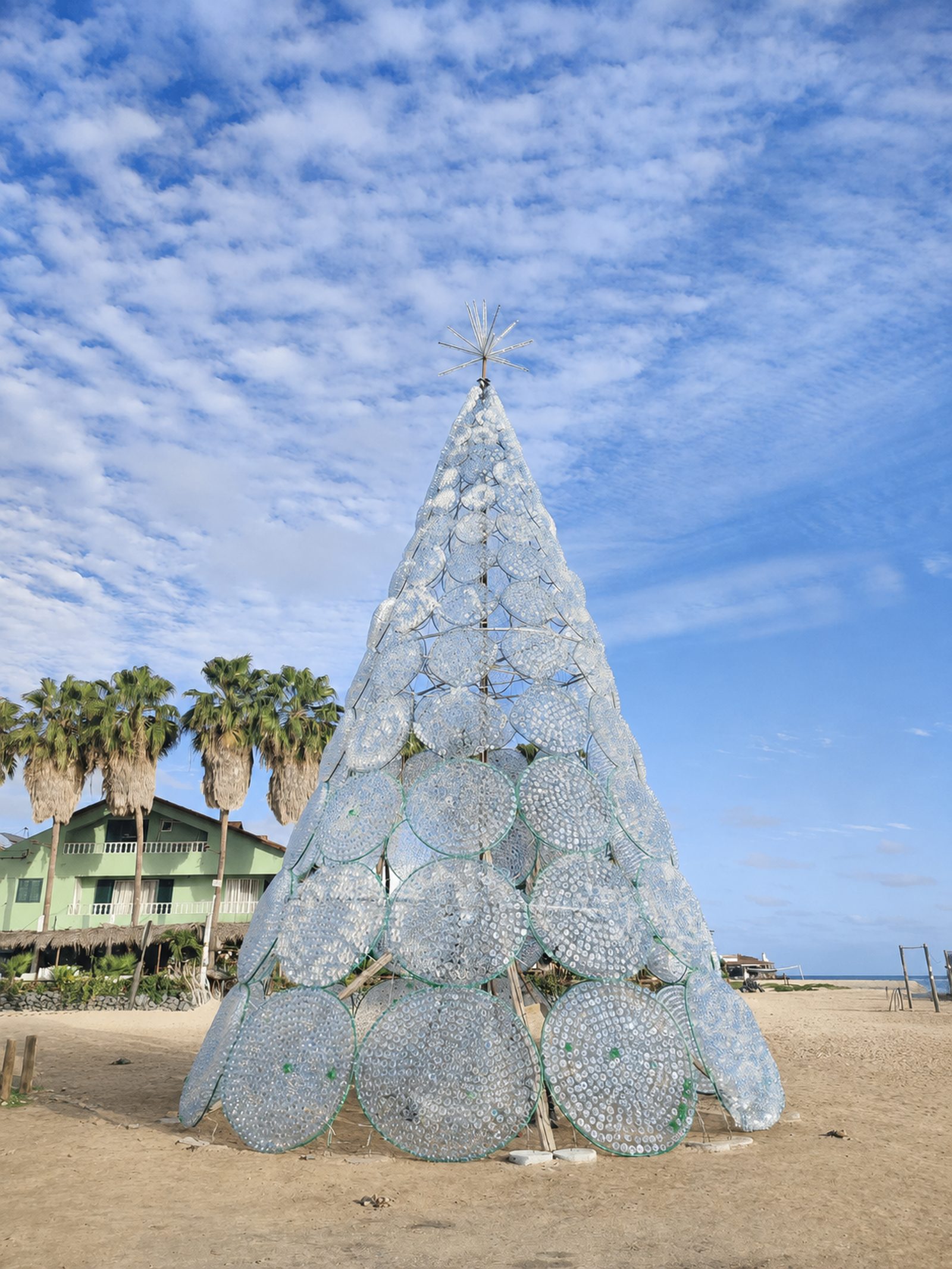 A Christmas tree built from recycled plastic bottles on the beach under a blue sky, Cape Verde
