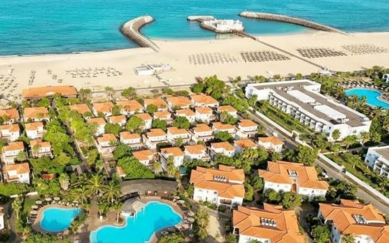 Aerial view of Meliá Tortuga Beach on Sal, Cape Verde: orange-roofed villas and pools set back from a sandy beach with stone breakwaters