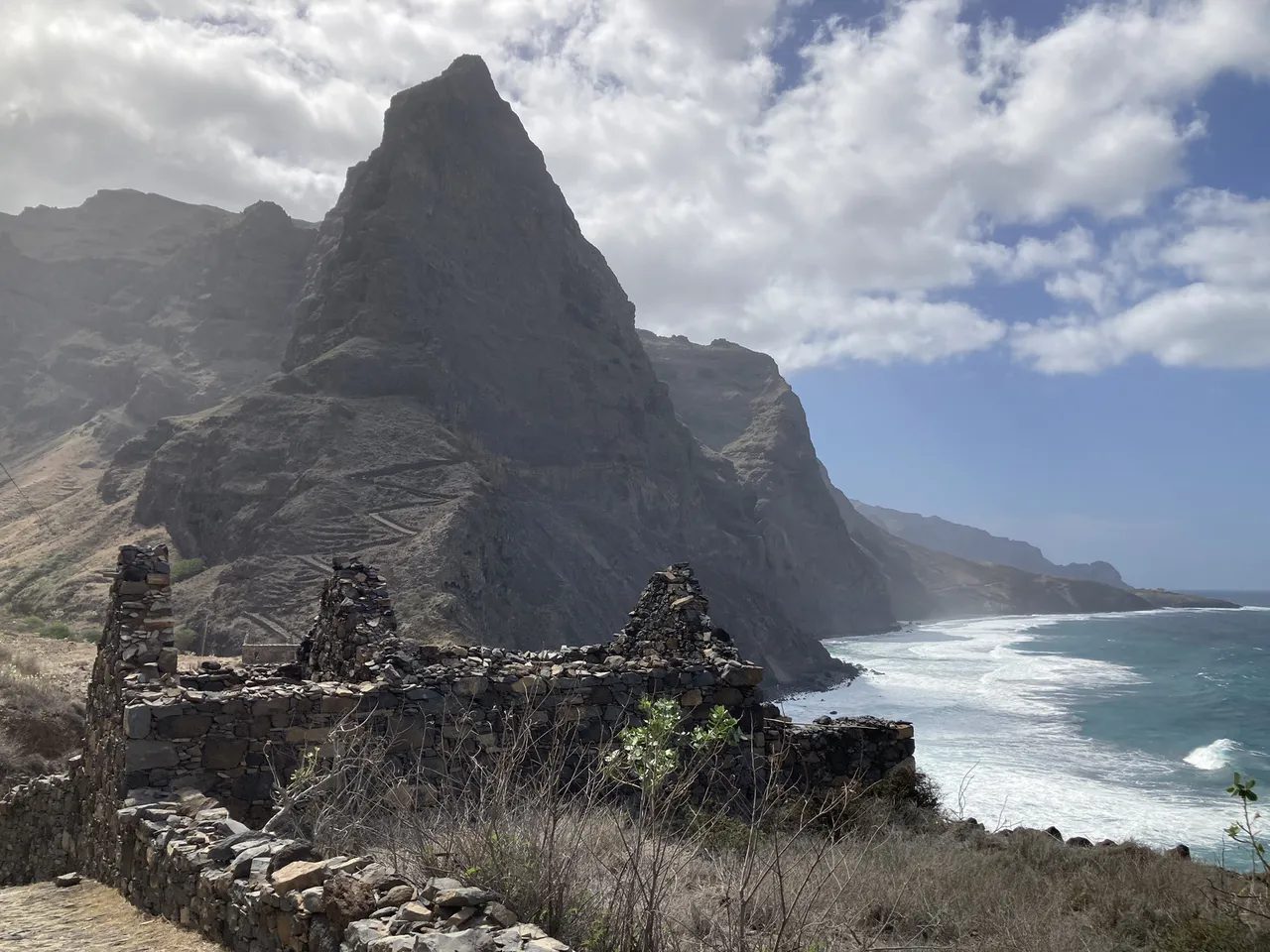 Stone ruins below a rock pinnacle on the coastal path between Ponta do Sol and Cruzinha, Santo Antão